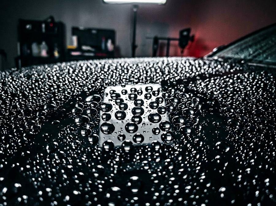 Water beading tightly on a coated car paint surface — FJ AUTOS services, Karachi